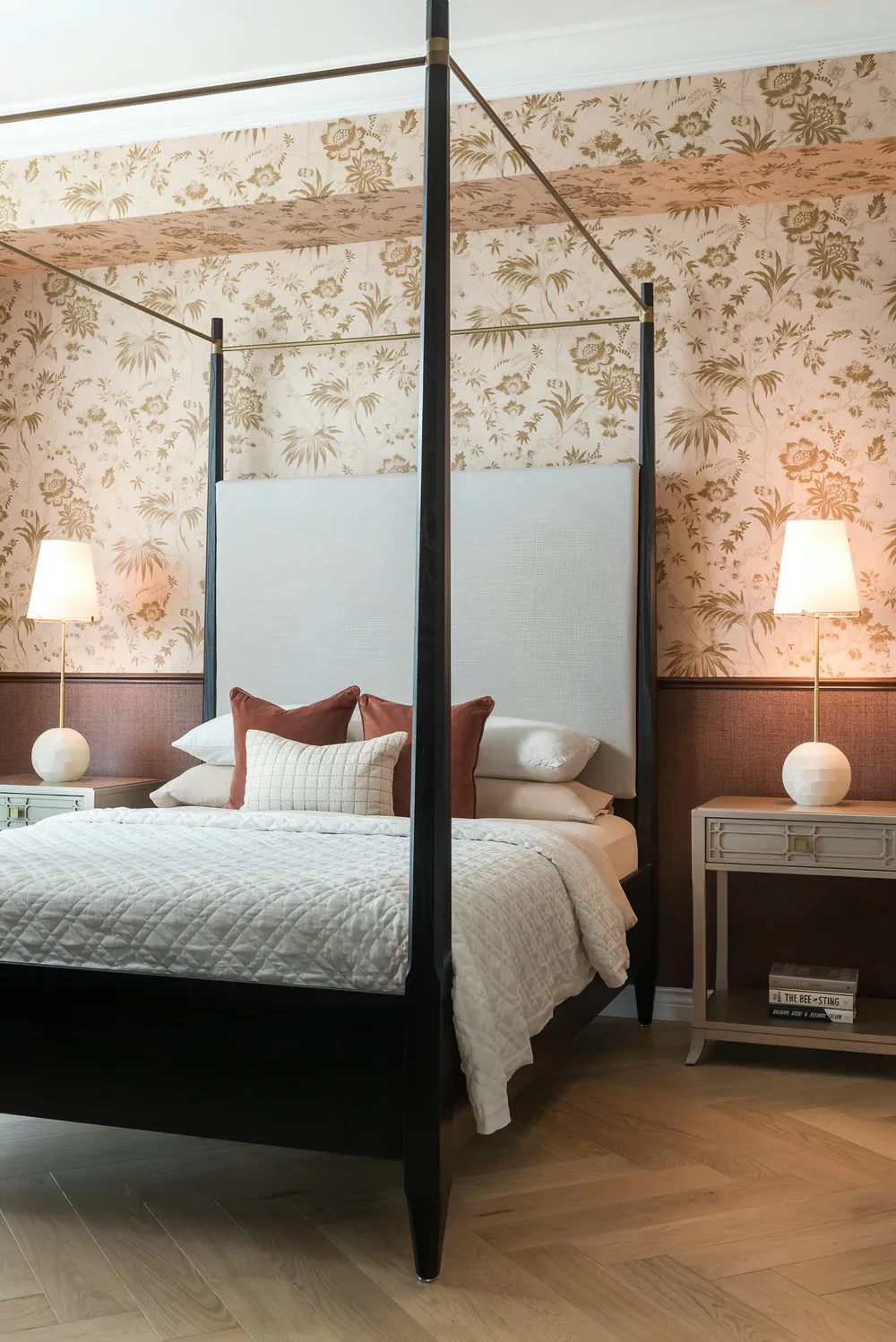 Bedroom with ebonized four-poster canopy bed, floral wallpaper over grasscloth wainscot and herringbone oak floor, at Art House in Downtown St. Petersburg. Interior design by MJ Designs