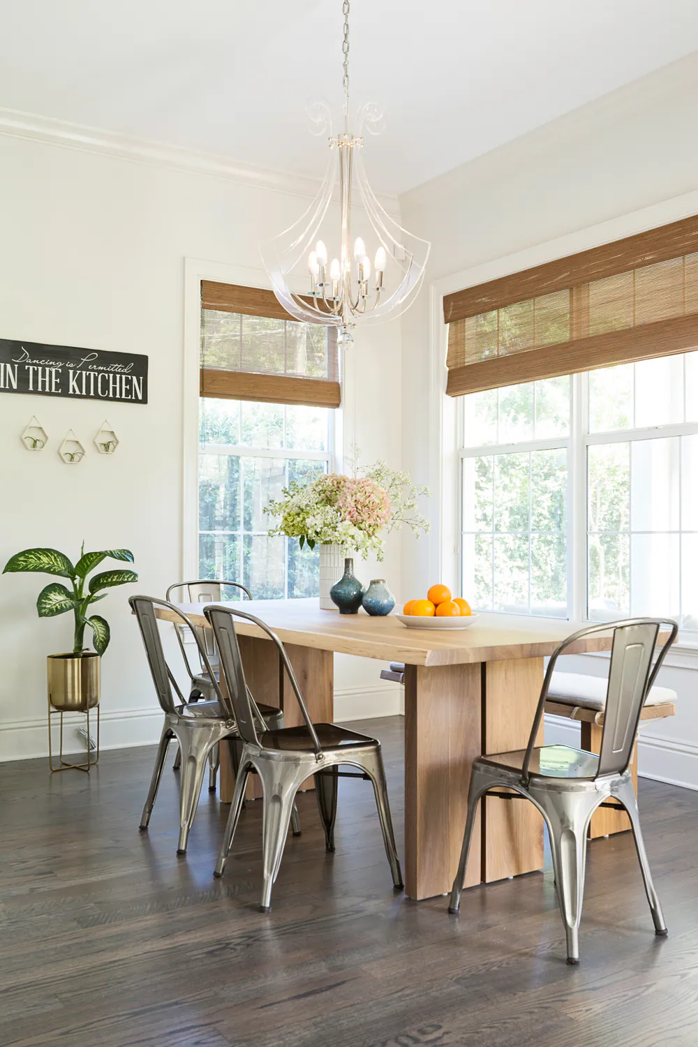 Breakfast nook with solid wood table, metal bistro chairs and acrylic chandelier, at Hyde Park in Tampa. Interior design by MJ Designs