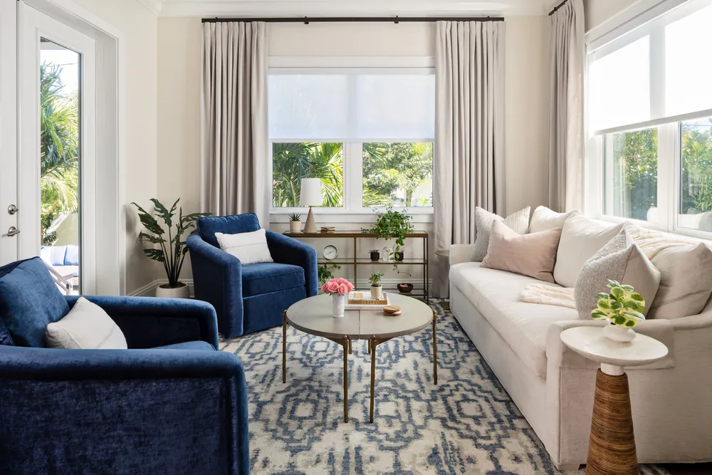 Sitting room with blue velvet swivel chairs, an ivory sofa and a blue and ivory patterned rug, at Snell Isle in St. Petersburg. Interior design by MJ Designs