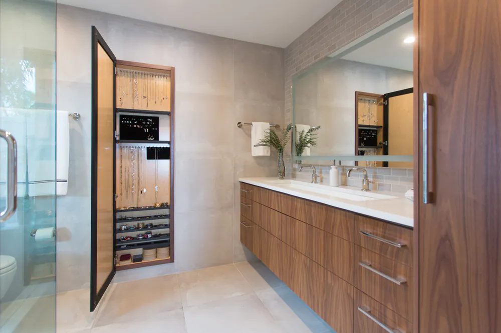 Primary bathroom with full-length mirror opened to a fitted jewelry cabinet beside the walnut vanity, at Yacht Club Estates in Tampa Bay. Interior design by MJ Designs